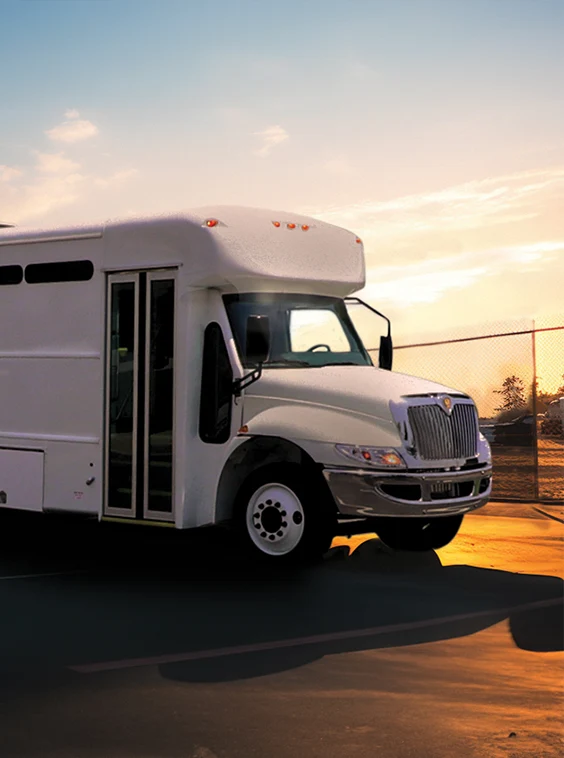 White shuttle bus parked next to a security fence at a prison near Indianapolis